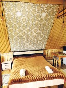 ein Schlafzimmer mit einem Bett in einem Zimmer mit Holzwänden in der Unterkunft Lavanda cottage in Werchowyna