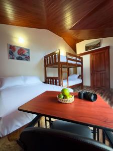 a room with a bed and a table with fruit on it at Brisas del Río in Mindo
