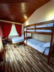 two bunk beds in a room with a wooden ceiling at Brisas del Río in Mindo