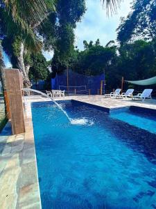 a swimming pool with two chairs and a swimming pool at Maresias Flat's Unidade II in Maresias