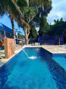 - une piscine avec une fontaine dans l'établissement Maresias Flat's Unidade II, à Maresias