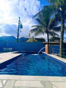 uma piscina com uma fonte de água em Maresias Flat's Unidade II em Maresias