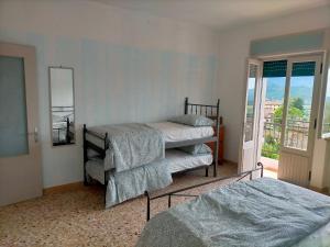 a bedroom with two beds and a balcony at Ca' del Laki in Caprino Veronese