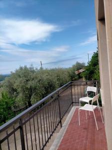 einen Balkon mit einem weißen Stuhl und einem Tisch in der Unterkunft Ca' del Laki in Caprino Veronese