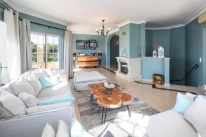 a living room with a white couch and a table at Casa do Verde at Presa de Moura near Carvoeiro and Ferragudo in Carvoeiro