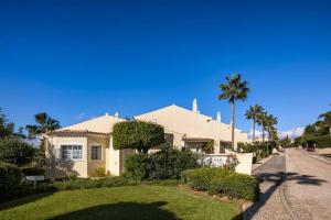 a white house with palm trees and a street at Casa do Verde at Presa de Moura near Carvoeiro and Ferragudo in Carvoeiro