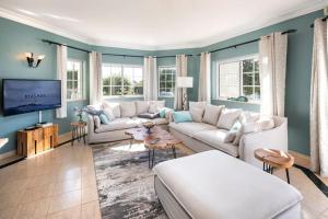 a living room with white couches and a tv at Casa do Verde at Presa de Moura near Carvoeiro and Ferragudo in Carvoeiro