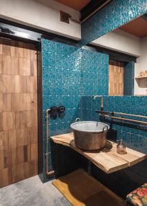 uma casa de banho com lavatório e azulejos azuis em Nyu Domo b&b em Sedilo