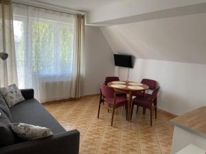 sala de estar con mesa, sillas y sofá en Apartamenty Ogrodowa en Jastarnia