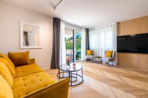 een woonkamer met een bank en een tv bij Dubrovnik Suite V in Dubrovnik