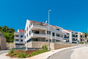 een wit appartementencomplex aan de kant van een weg bij Dubrovnik Suite V in Dubrovnik