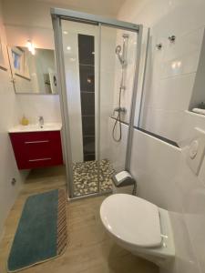 uma casa de banho com um chuveiro, um WC e um lavatório. em Apartments Oaza em Split