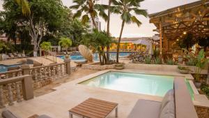 una piscina en un hotel con mesa y sillas en Hotel Caribe by Faranda Grand, a member of Radisson Individuals, en Cartagena de Indias