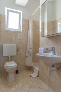 łazienka z toaletą i umywalką w obiekcie Rasin Apartments w Pakoštane