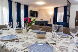 mesa de comedor con anteojos y platos azules y blancos en Villa Yanna, en Benalmádena