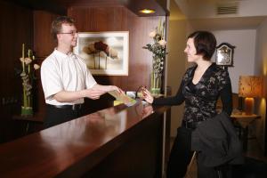 a man and a woman standing at a counter at Hotel St. Pierre in Bad Hönningen