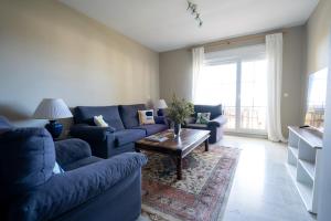 ein Wohnzimmer mit blauen Sofas und einem Tisch in der Unterkunft Seaview and big terrace Cabopino in Marbella