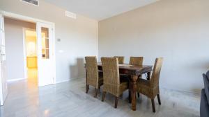 uma sala de jantar com uma mesa de madeira e cadeiras em Seaview and big terrace Cabopino em Marbella