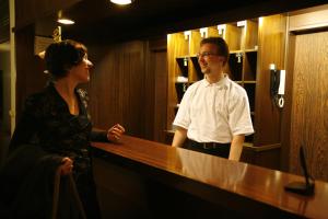 a man and a woman standing at a counter at Hotel St. Pierre in Bad Hönningen