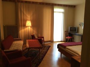 ein Hotelzimmer mit einem Bett und Stühlen sowie einem TV in der Unterkunft Hotel Garni - Appartements Fuksas in Bad Gleichenberg