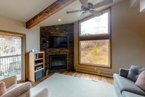 a living room with a fireplace and a tv at Snowmass Village 19E in Snowmass Village