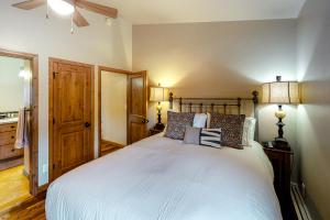 a bedroom with a large white bed with two lamps at Snowmass Village 19E in Snowmass Village