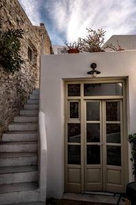 - une porte menant à un bâtiment avec des escaliers à côté dans l'établissement mikro.kastro kalotaritissa in Chora Amorgos, à Amorgós