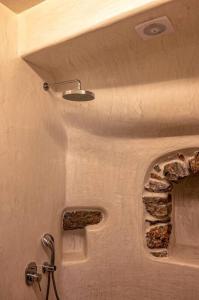 a bathroom with a stone wall with a window at mikro.kastro kalotaritissa in Chora Amorgos in Amorgos