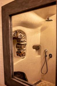 lustro w łazience z kominkiem w obiekcie mikro.kastro kalotaritissa in Chora Amorgos w mieście Amorgós