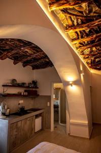 a kitchen with an archway with a counter and a sink at mikro.kastro kalotaritissa in Chora Amorgos in Amorgos