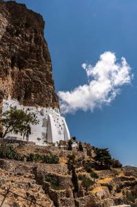 a white building on the side of a mountain at mikro.kastro kalotaritissa in Chora Amorgos in Amorgos