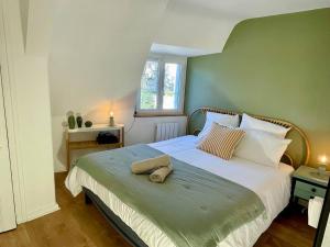 a bedroom with a large bed with a green wall at Rochecorbon - Bouchon de Loire in Rochecorbon