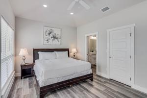 ein weißes Schlafzimmer mit einem Bett und einer Tür in der Unterkunft Vacation's Callin' on Ports O Call in Padre Island