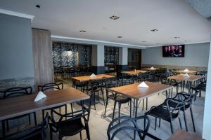 a restaurant with tables and chairs in a room at Nuevo Centro Hotel Villa Carlos Paz in Villa Carlos Paz