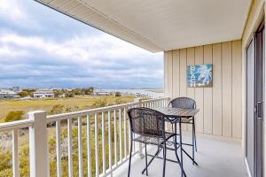 uma varanda com duas cadeiras e uma mesa em Bay Creek Villa - 304 em Edisto Island