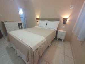 聖何塞皇冠大的住宿－Casa Praia São Jose Maragogi 4，卧室配有一张床,墙上有两盏灯
