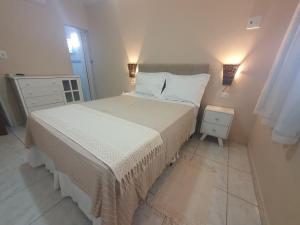 a bedroom with a bed and two lights on the wall at Casa 3quartos rota Maragogi Carneiros in São José da Coroa Grande