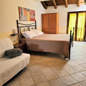 a bedroom with two beds and a couch at Cinque Abeti Agrialloggio Mountain Lake Iseo Hospitality in Bossico