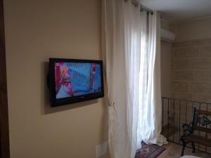 a flat screen tv on a wall next to a window at CASA ENRICA in Adelfia