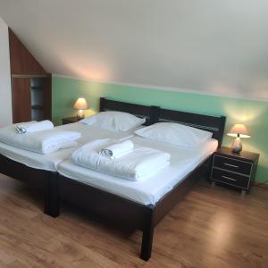 1 dormitorio con 2 camas y almohadas blancas en Cztery Pory Roku, en Białowieża
