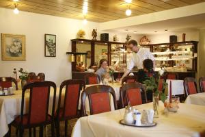 巴特亨寧根的住宿－聖皮埃爾酒店，坐在餐厅桌子上的男人和孩子