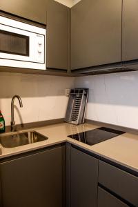 a kitchen with a sink and a microwave at Apartamentos Lidar in Bilbao
