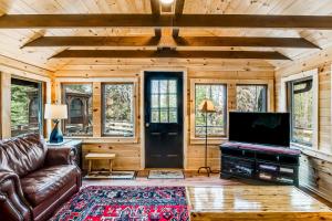 a living room with a couch and a tv at Three Bears Lodge in Boulder Junction