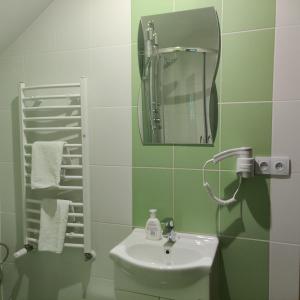 a bathroom with a sink and a mirror and towels at Cztery Pory Roku in Białowieża