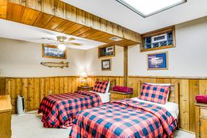 twee bedden in een kamer met houten lambrisering bij Three Bears Lodge in Boulder Junction