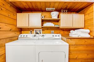 a white washing machine in a kitchen with wooden walls at Three Bears Lodge in Boulder Junction +31 photos