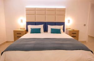 ein Schlafzimmer mit einem großen Bett mit blauem Kopfteil in der Unterkunft Luxury Apartments Sabi Waikiki con garaje in Corralejo