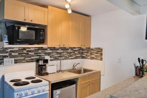 a kitchen with a stove and a sink and a microwave at Shortboard in Holmes Beach
