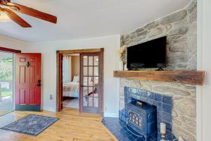 a living room with a stone fireplace and a tv at Cookie Cottage in Black Mountain