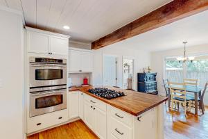 a kitchen with white cabinets and a stove top oven at Cookie Cottage in Black Mountain